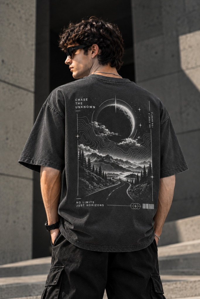 Model wearing the dark grey INFONORAY Chase the Unknown oversized T-shirt, showing its cosmic mountain road back design