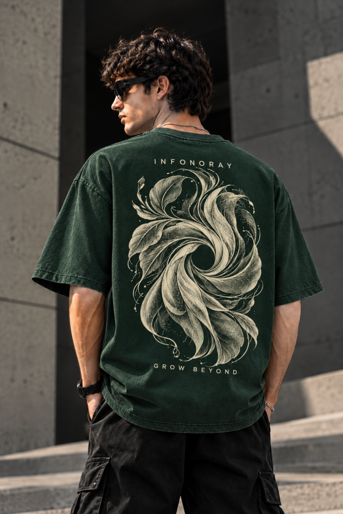 Model wearing the dark forest-green INFONORAY oversized tee with ivory botanical vortex artwork and GROW BEYOND lettering on the back.