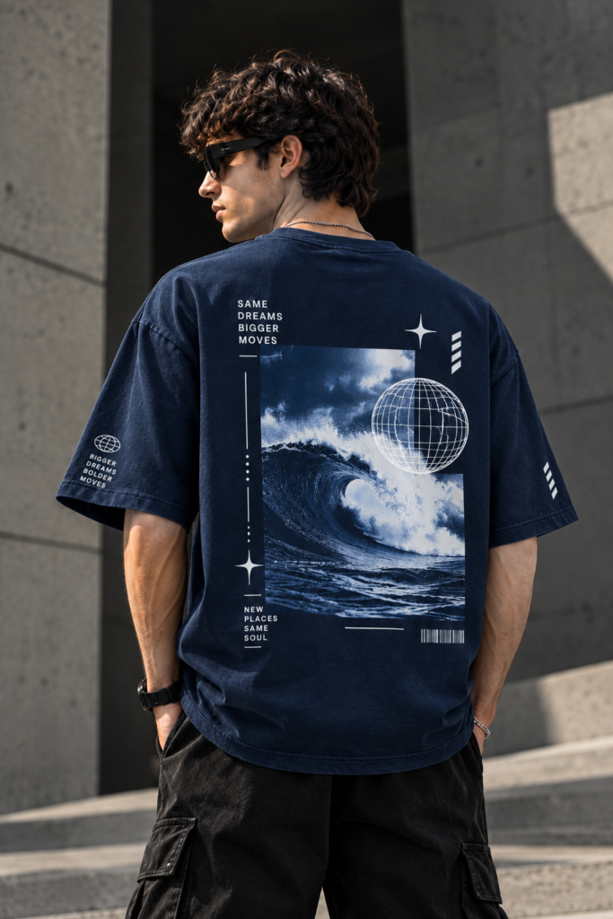Model wearing the navy INFONORAY Same Dreams Bigger Moves oversized T-shirt, showing its ocean wave and wireframe globe back design